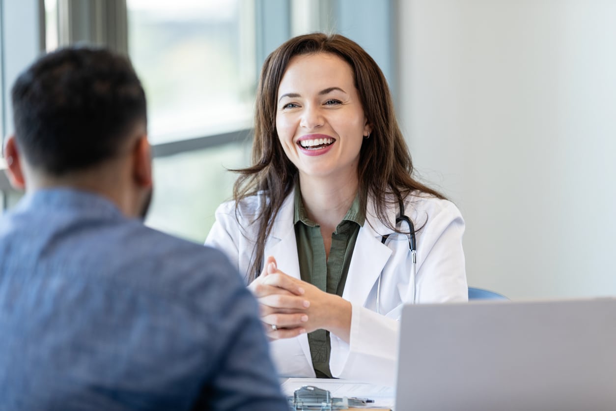 Cheerful doctor talks with male patient